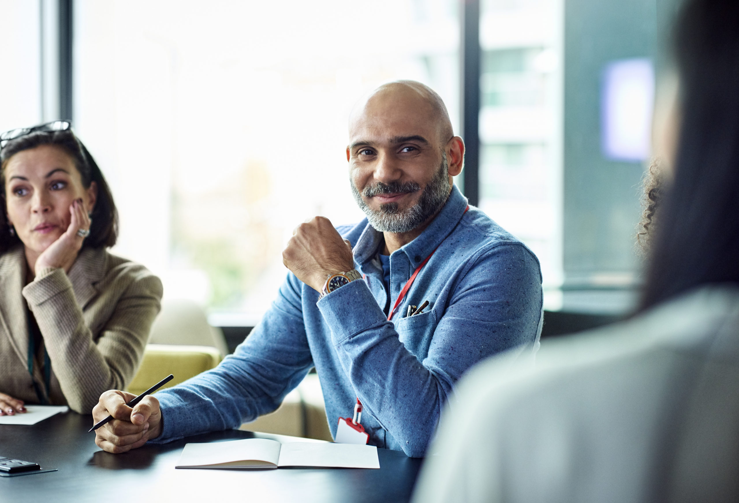 Portrait of smiling mature businessman at meeting in modern office during a four-day workweek