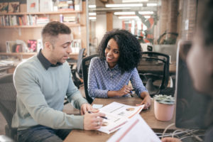 Smiling woman and man looking over benefits paperwork