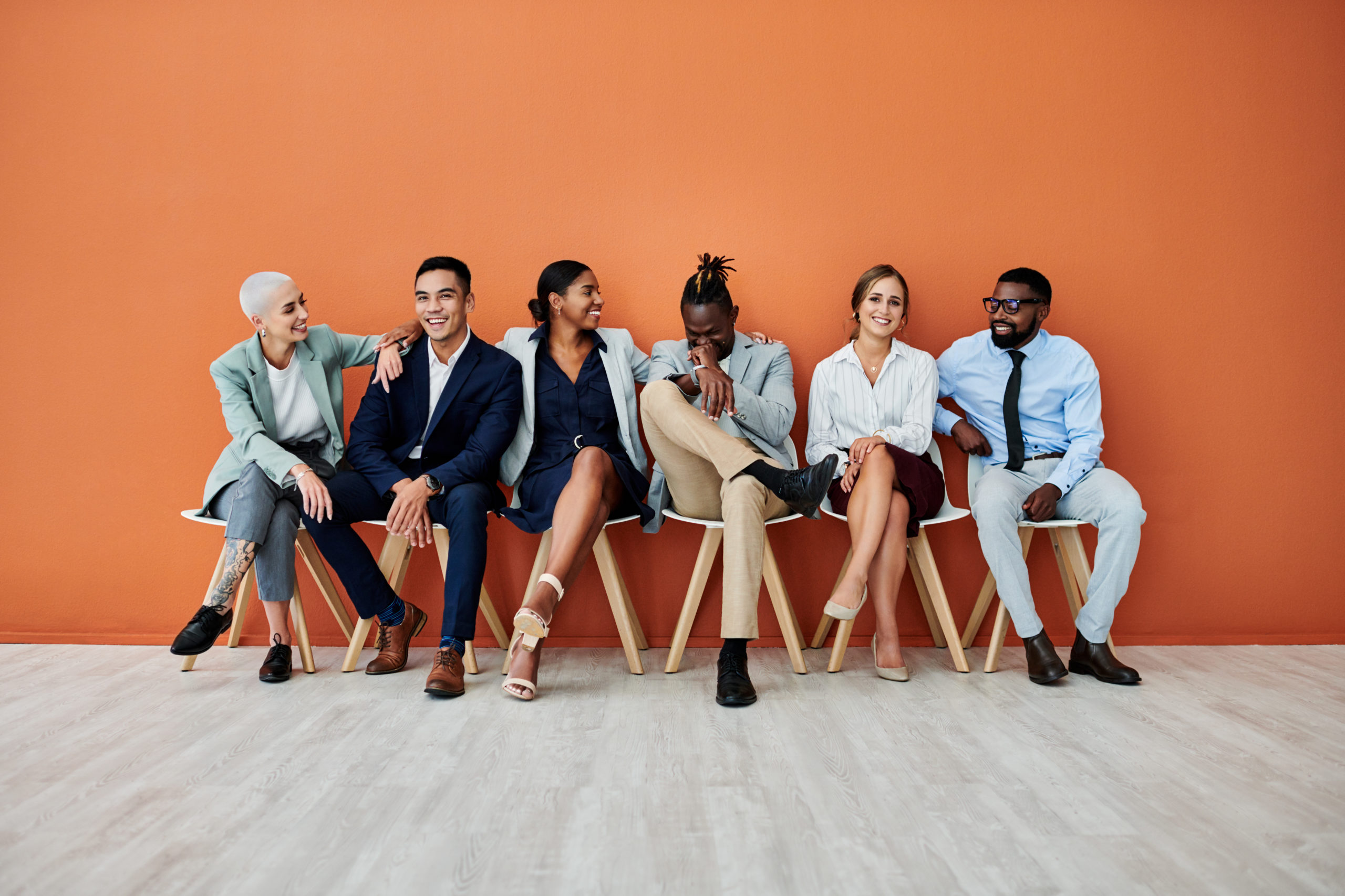 Shot of a group of businesspeople sitting against an orange background