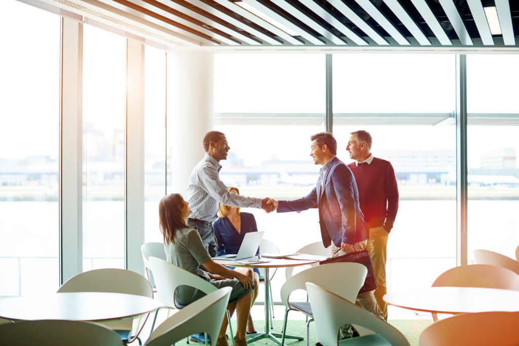 Shot of two business colleagues shaking hands during a meeting in the boardroom