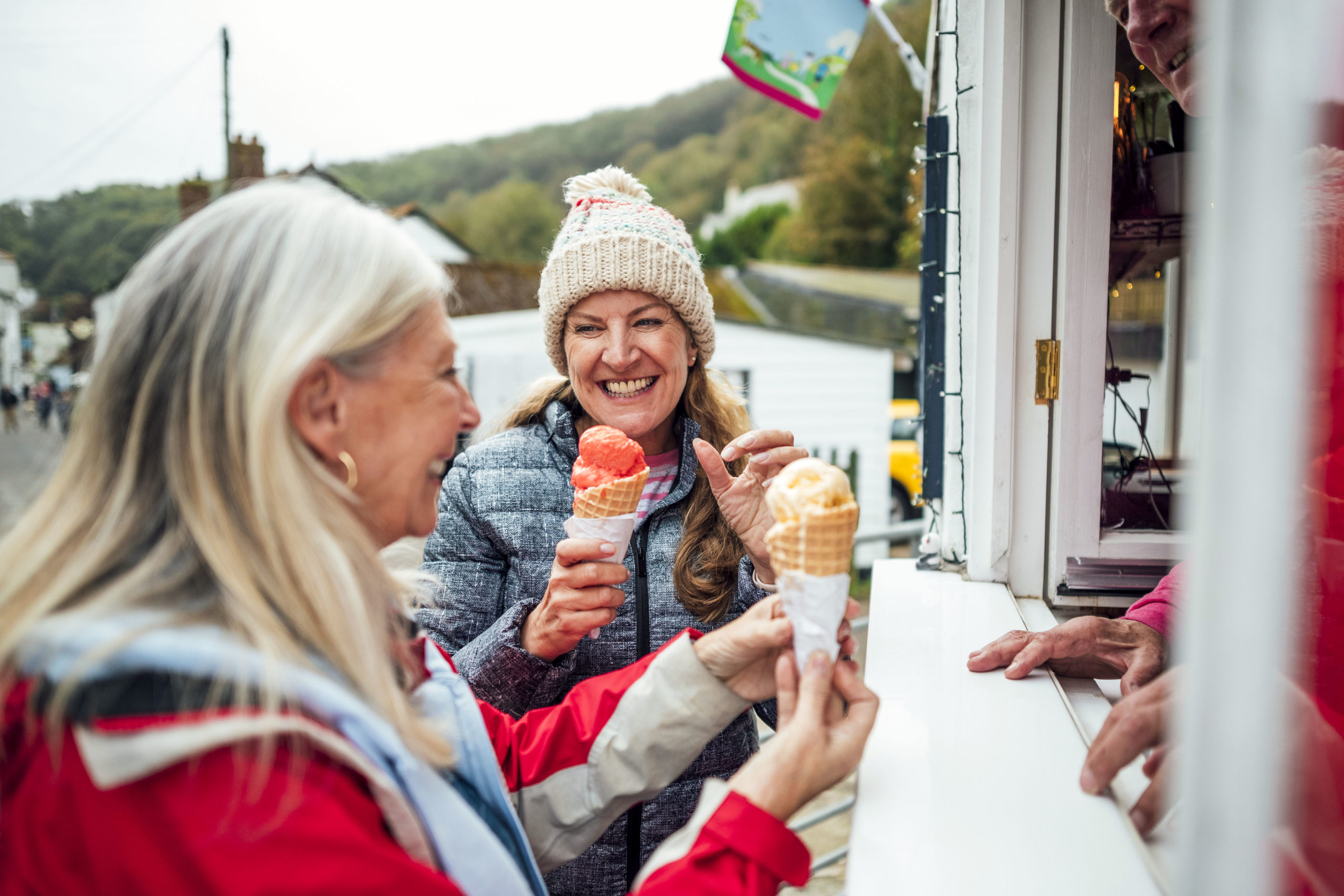 A shot of two mature women getting ice-creams from an ice cream parlor in Cornwall.