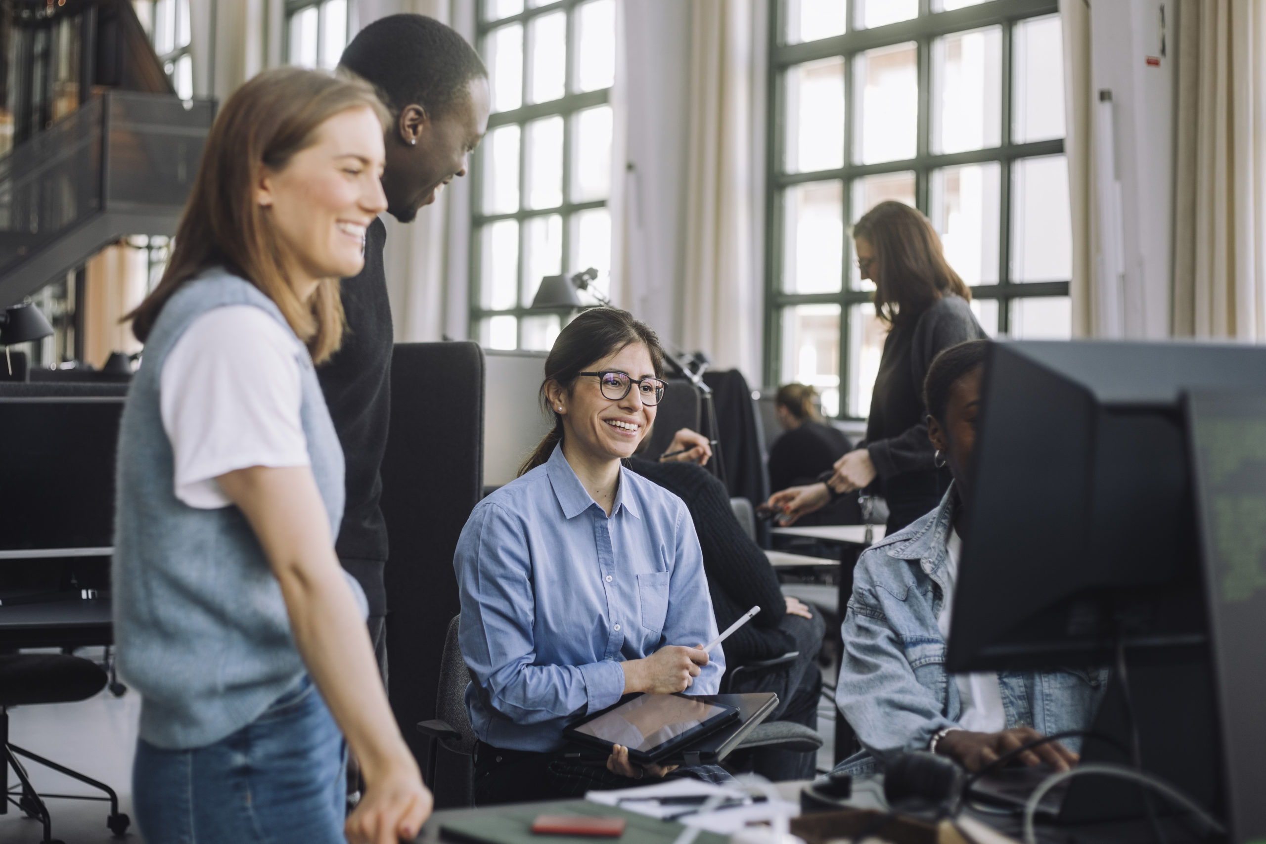 Smiling investor with male and female HRO consultants at desk in office