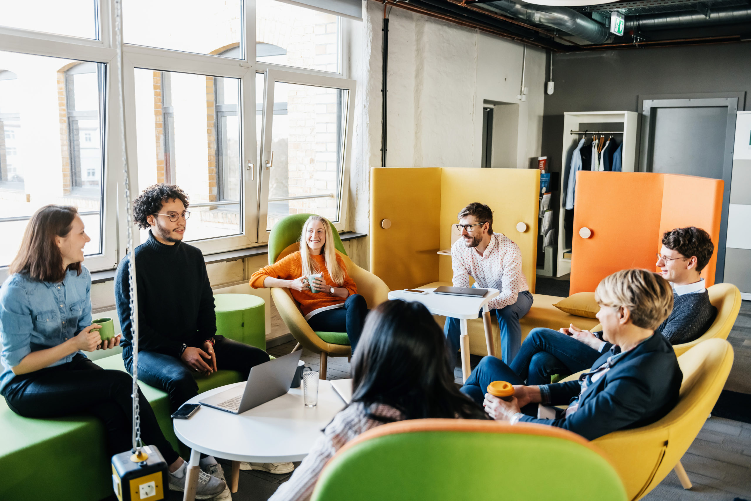 A group of business employees sitting down together and brainstorming during a meeting at the office.