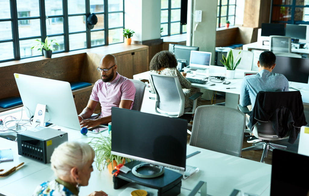 Businessmen and women using computers and concentrating on HR compliance, modern office environment, efficiency, productivity, corporate business