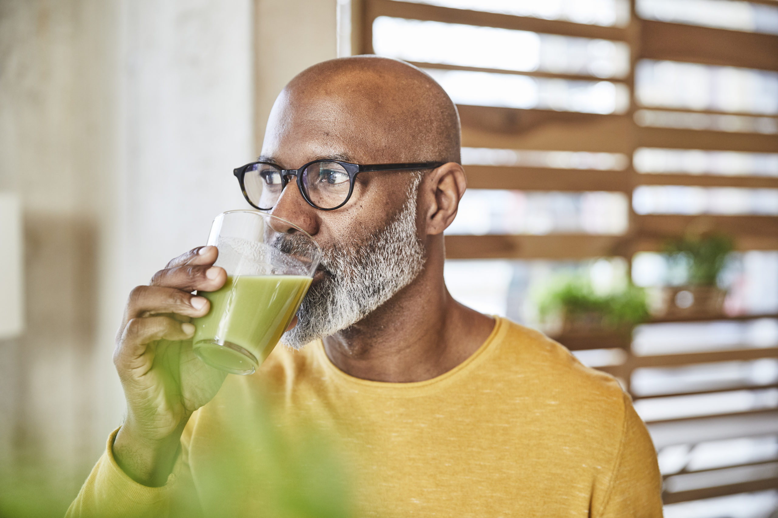 Mature businessman in office drinking a smoothie as part of an employee wellness initiative