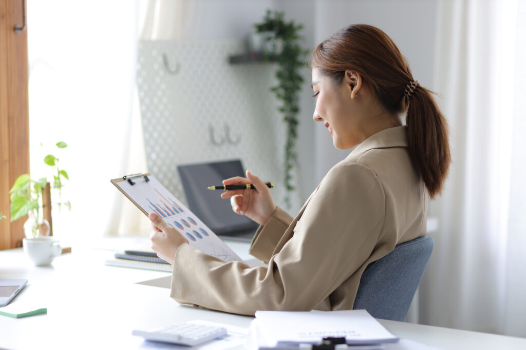 Business woman holding financial report analyzing and planning how HR drives revenue.