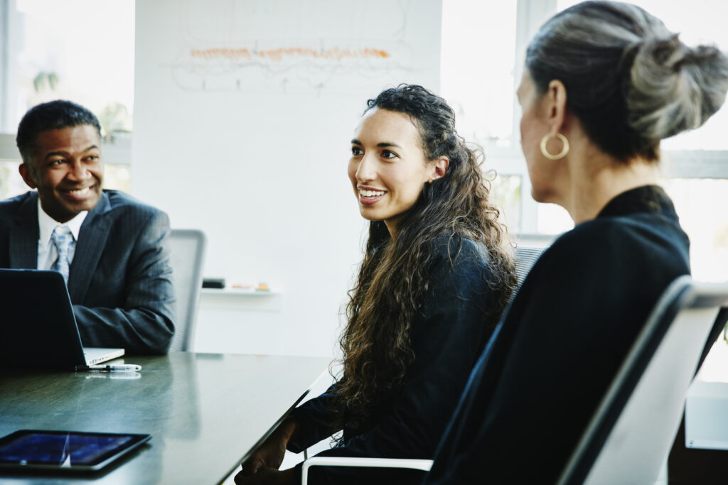 Smiling businesswoman leading discussion during executive coaching in office conference room
