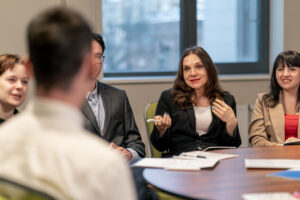 A meeting of five business people discussing their outsourced HR needs with ADDA round a conference table